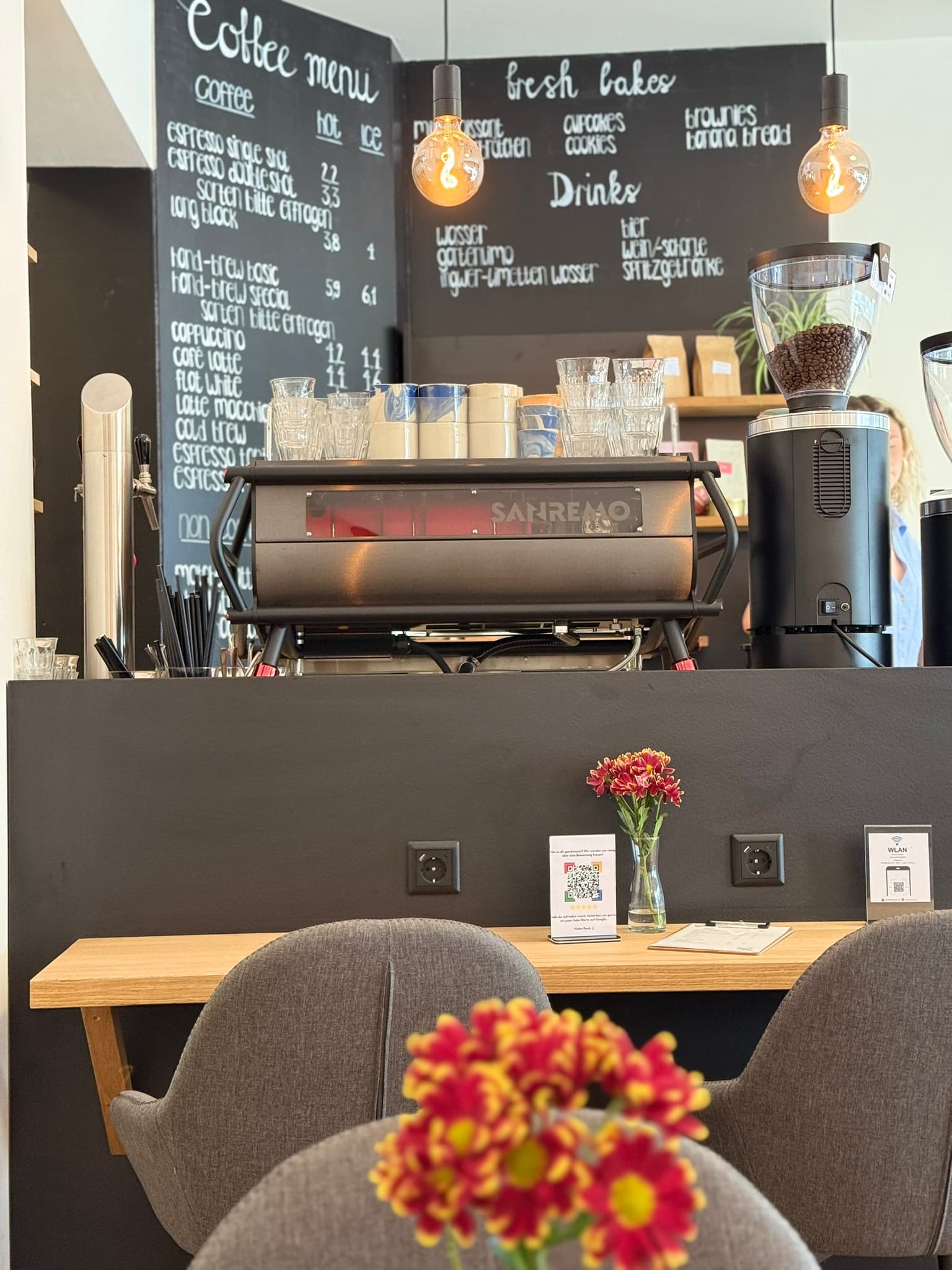 Die Café-Theke im KOKO Coffee Lab mit San Remo Siebträgermaschine, Coffee-Menu auf Kreidetafel und professioneller Kaffeemühle